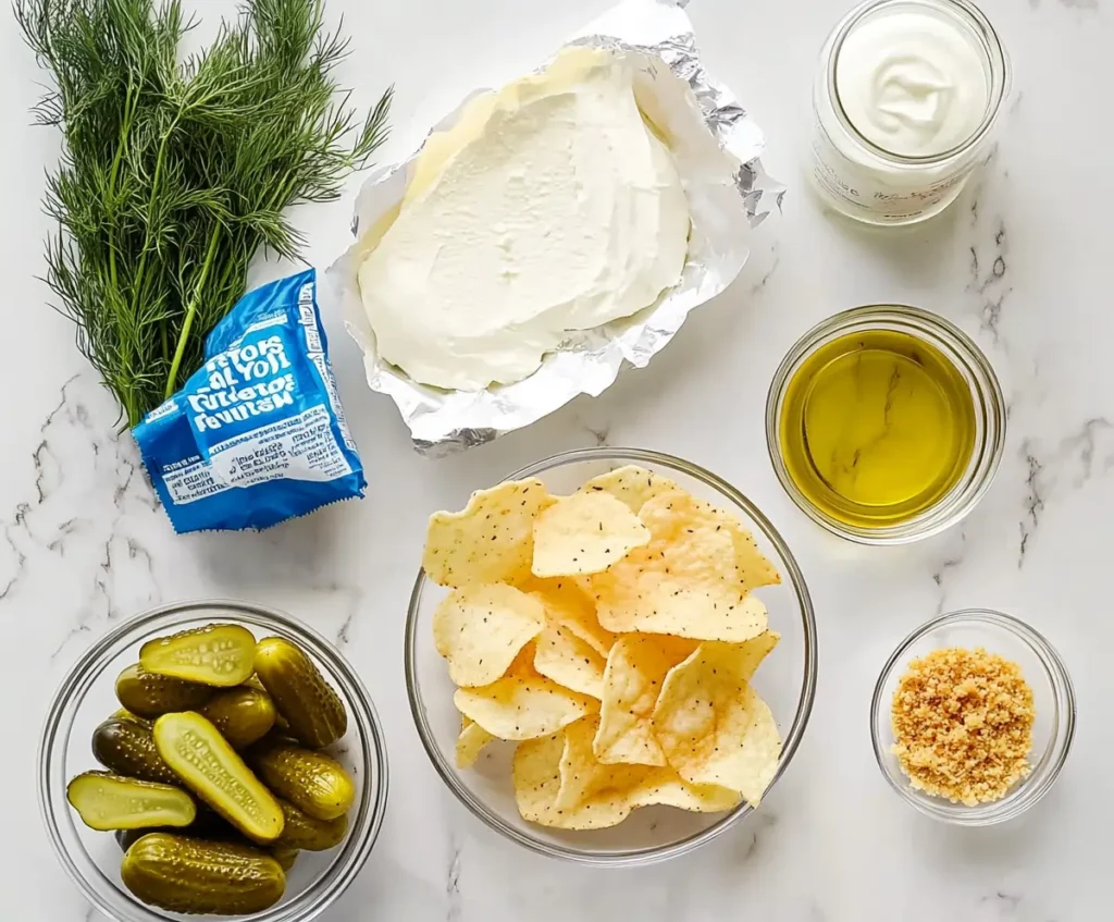 Various ingredients for Fried Pickle Dip, including a block of cream cheese, chopped pickles,